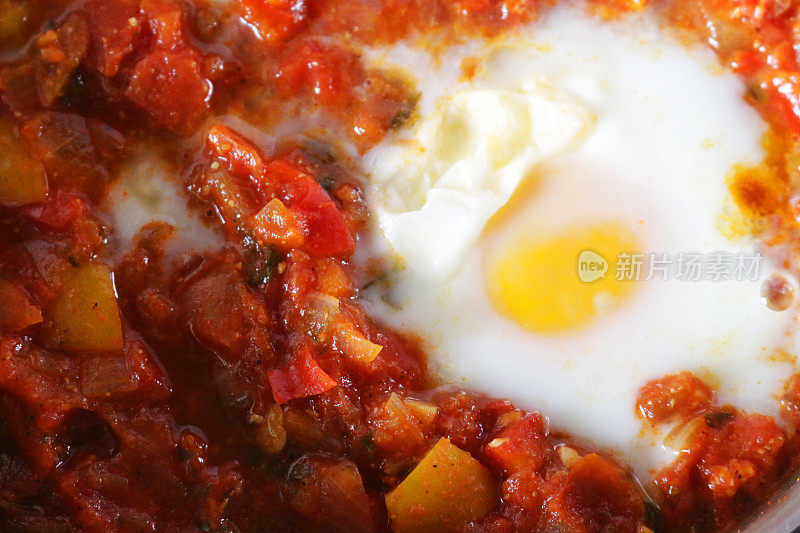 地中海健康早餐shakshouka / shakshuka / chakchouka在平底锅里，鸡蛋煮在西红柿、辣椒、洋葱、橄榄油和大蒜的酱汁里